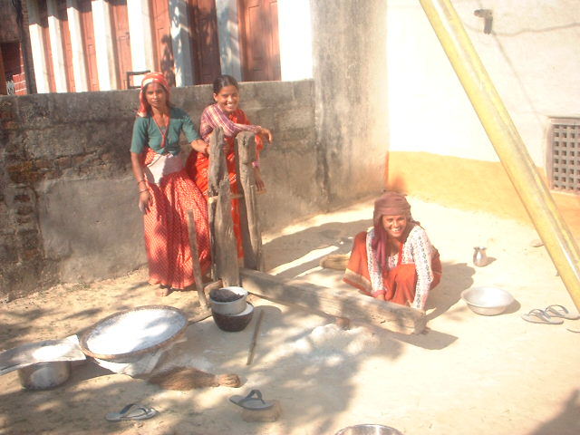 小さな村、足踏み式で粉をひく女性たち。