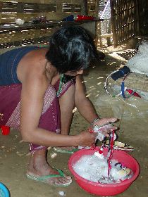 頭飾りを洗うアカ族の女性